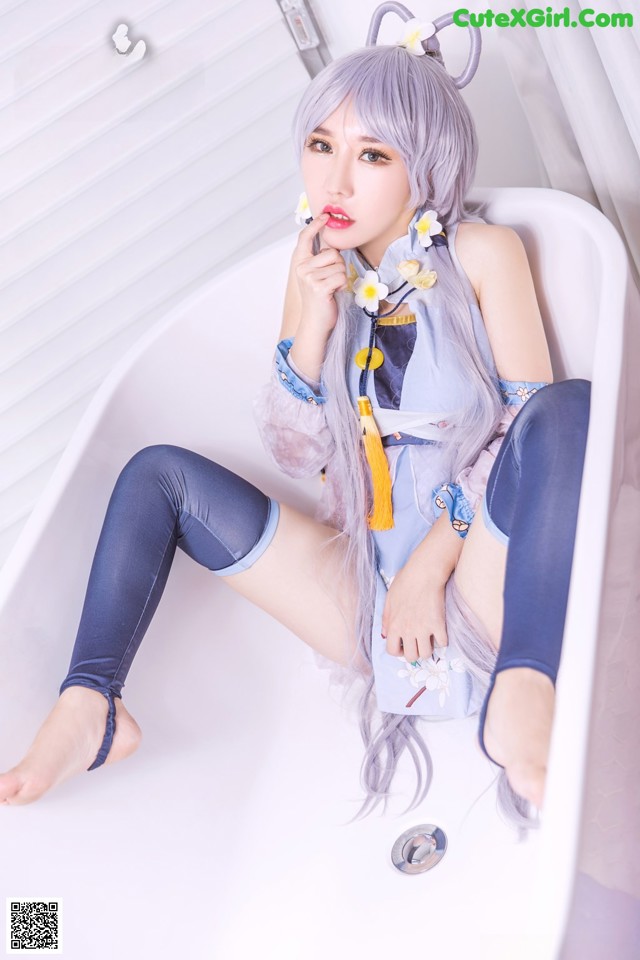 A woman sitting in a bathtub with her legs crossed.