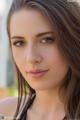 A beautiful young woman with long brown hair posing for a picture.