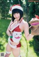 A woman in a santa claus outfit holding a stuffed animal.