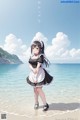 A woman in a maid outfit standing on a beach.