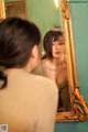 A woman looking at herself in the mirror. 