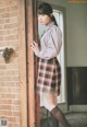 A woman standing in front of a brick wall.