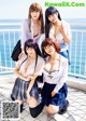 A group of young women posing for a picture on a balcony.