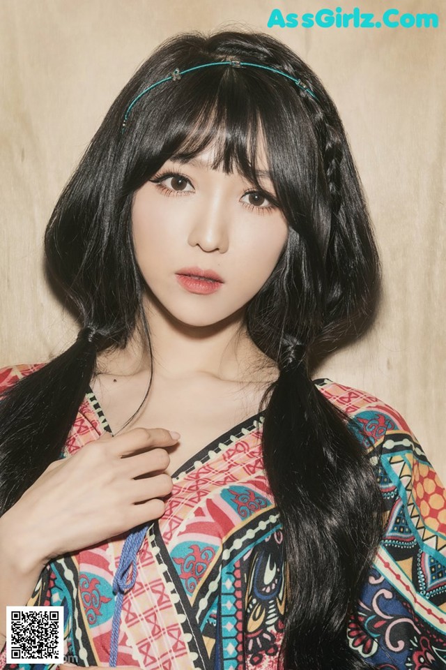 A woman with long black hair wearing a colorful dress.