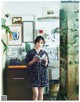 A woman standing in a kitchen holding a book.