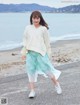 A woman walking on a beach next to the ocean.