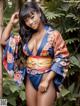 A woman in a blue and orange kimono posing for a picture.