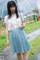 A woman holding an umbrella standing in the rain.