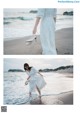 A woman in a white dress is walking on the beach.