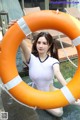 A woman in a white bathing suit holding a life preserver.